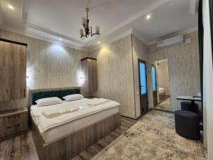 a bedroom with a large bed and a bathroom at YASMIN in Samarkand