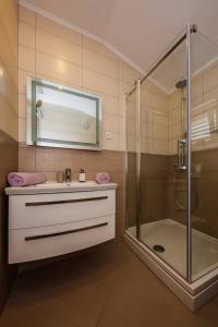 a bathroom with a sink and a shower at Apartmani Savin in Brodarica +26 photos