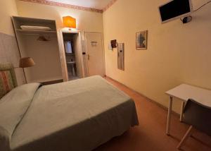 a bedroom with a bed and a table and a television at Hotel Ely in Viareggio +20 photos