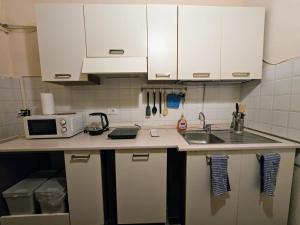 a small kitchen with white cabinets and a sink at Stay in the heart of Pisa at Dietro al Corso in Pisa