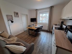 a living room with a table and a kitchen with a couch at for 4 - parking space for car - Internet in Bielefeld
