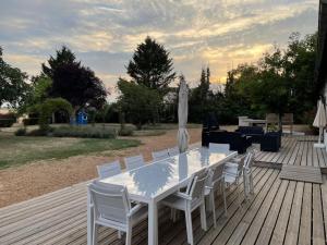a white table and chairs on a wooden deck at Kasa Des Bois in Saint-Arnoult-des-Bois +37 photos