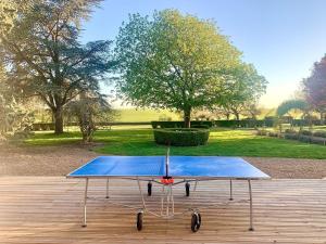 a ping pong table sitting on a wooden deck at Kasa Des Bois in Saint-Arnoult-des-Bois