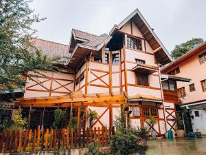 a house with a wooden fence in front of it at Pousada Bella Giornata in Campos do Jordão
