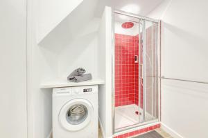 a bathroom with a washing machine and a shower at Terracotta in Carrières-sous-Poissy
