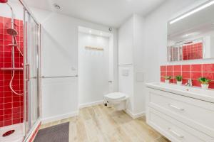 a bathroom with a toilet and a shower with red tiles at Terracotta in Carrières-sous-Poissy