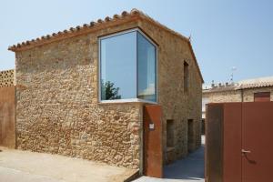 een raam aan de zijkant van een bakstenen gebouw bij CAN COSTA in Pals