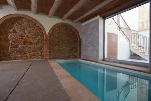 a swimming pool in a house with a stone wall at CAN COSTA in Pals