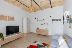 a living room with a couch and a flat screen tv at La casa nel verde - YourPlace Abruzzo in Rocca San Giovanni