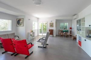 a living room with red chairs and a table at Villa Elvise - YourPlace Abruzzo in Fossacesia