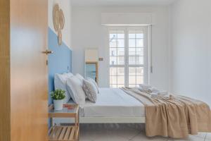 a white bedroom with a bed and a window at Ferrante - YourPlace Abruzzo in Fossacesia