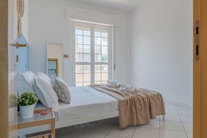 a white bedroom with a bed and a window at Ferrante - YourPlace Abruzzo in Fossacesia