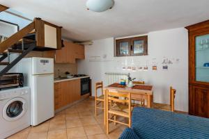 a kitchen with a table and a white refrigerator at La casetta di Nonna Nice - YourPlace Abruzzo in Rocca San Giovanni