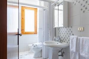 a white bathroom with a sink and a toilet at Appartamento Venere - YourPlace Abruzzo in Fossacesia +19 photos