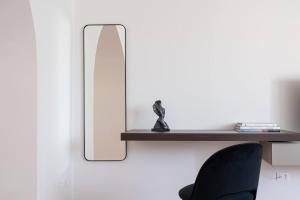 a mirror on a wall next to a black chair at Villa Carulli - YourPlace Abruzzo in Villa Caldari