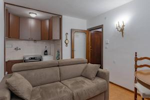 een woonkamer met een bank en een keuken bij Via Roma 44 - YourPlace Abruzzo in Roccaraso