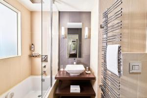 a bathroom with a sink and a shower and a tub at Hôtel Barrière Le Gray d'Albion in Cannes