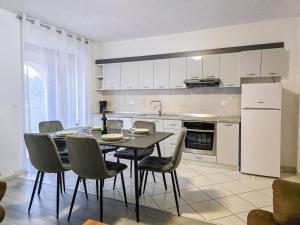 kuchnia ze stołem, krzesłami i lodówką w obiekcie Apartment Dunato I w mieście Šilo