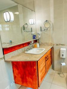 a bathroom with a sink and a mirror at Pousada Bella Giornata in Campos do Jordão +159 photos