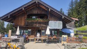 un edificio con balcone con posti a sedere ai tavoli di Grosse Wohnung mit Garten und Bergblick a Rottach-Egern