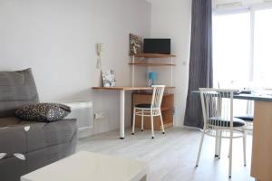 a living room with a couch and a table and chairs at Appt Studio LA ROCHELLE - LR030-A119Z in La Rochelle