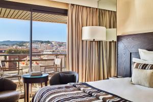 a hotel room with a bed and a balcony at Hôtel Barrière Le Gray d'Albion in Cannes
