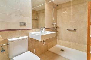a bathroom with a toilet and a sink at Penthouse by the beach in Torrox Costa +25 photos