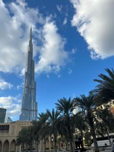 a view of the burj khalifa with palm trees at Dubai mall Aparment in Dubai