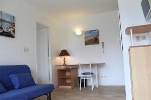 a living room with a blue couch and a table at Appt 2 pièces LA ROCHELLE - LR030-E116 in La Rochelle