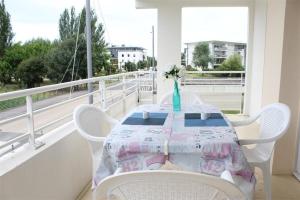 a table on a balcony with a vase on it at Appt 2 pièces LA ROCHELLE - LR030-E116 in La Rochelle