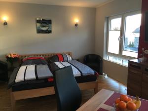 a bedroom with two beds and a table with a bowl of fruit at Ferienwohnung - Marburg in Marbach