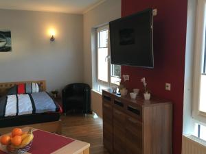 a living room with a bed and a television on a wall at Ferienwohnung - Marburg in Marbach