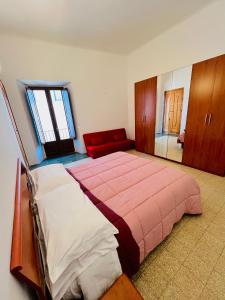 a bedroom with a large bed and a red couch at Regina d’Aragona casa vacanze in Sulmona