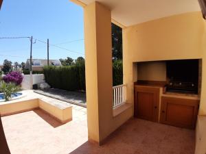 Blick auf eine Terrasse mit einem TV und einem Balkon in der Unterkunft Villa Naomi in Les tres Cales