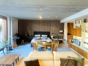 a living room with a couch and a bed and a table at Sweet Valley Cozy in Zutendaal