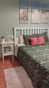 a bedroom with a bed and a nightstand with a table at Timón, cerca de la Playa in Candás