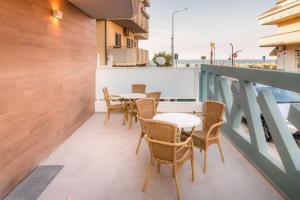a balcony with tables and chairs on a building at Residence Near The Sea - Abruzzo in Martinsicuro