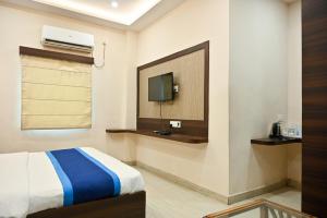 a bedroom with a bed and a tv on a wall at Hotel Hari Gopal in Varanasi
