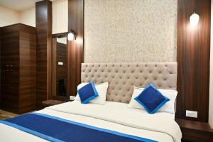 a bedroom with a large bed with blue pillows at Hotel Hari Gopal in Varanasi