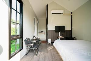 a bedroom with a bed and a desk and a tv at Zeevila in Sattahip