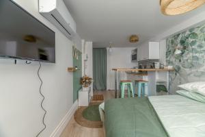 a small apartment with a bed and a kitchen at Le Jardin Secret - Centre ville - WIFI - by CLÉ HÔTES in Saint-Vallier +12 photos