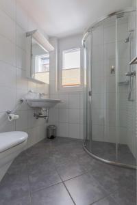 een witte badkamer met een douche en een wastafel bij Sunnagarta in Davos