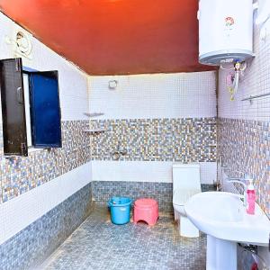 un baño con lavabo e inodoro en WoodWalk Homestay, Bhimtal, en Bhowāli 37 fotos más