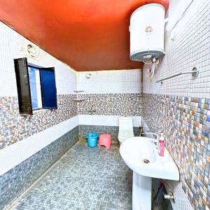 un baño con lavabo e inodoro en WoodWalk Homestay, Bhimtal, en Bhowāli