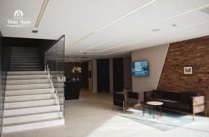 a lobby with a staircase and a couch and a table at Hotel Bank in Kiseljak