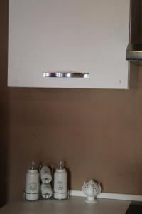 a kitchen counter with three white candles on it at Floriads Apartments Caramel in Mondovì