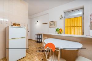 a kitchen with a white refrigerator and a table at #258 Travessa do Mar F by Home Holidays in Albufeira