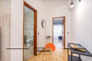 a bathroom with a toilet and a door with a house holidays sign at #258 Travessa do Mar F by Home Holidays in Albufeira