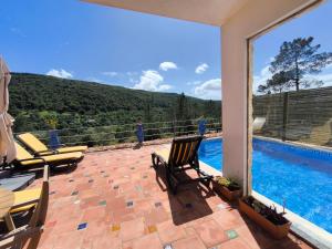 a patio with chairs and a swimming pool at Casa-Diospiro-villa-for-4P-baby-with-private-pool in São Bartolomeu de Messines