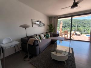 a living room with a couch and a glass table at Casa-Diospiro-villa-for-4P-baby-with-private-pool in São Bartolomeu de Messines